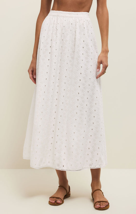 White lace skirt worn by a person on a plain background