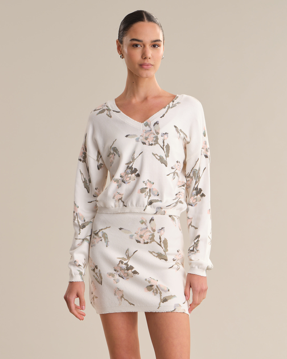 Woman wearing a white dress with floral pattern on a beige background