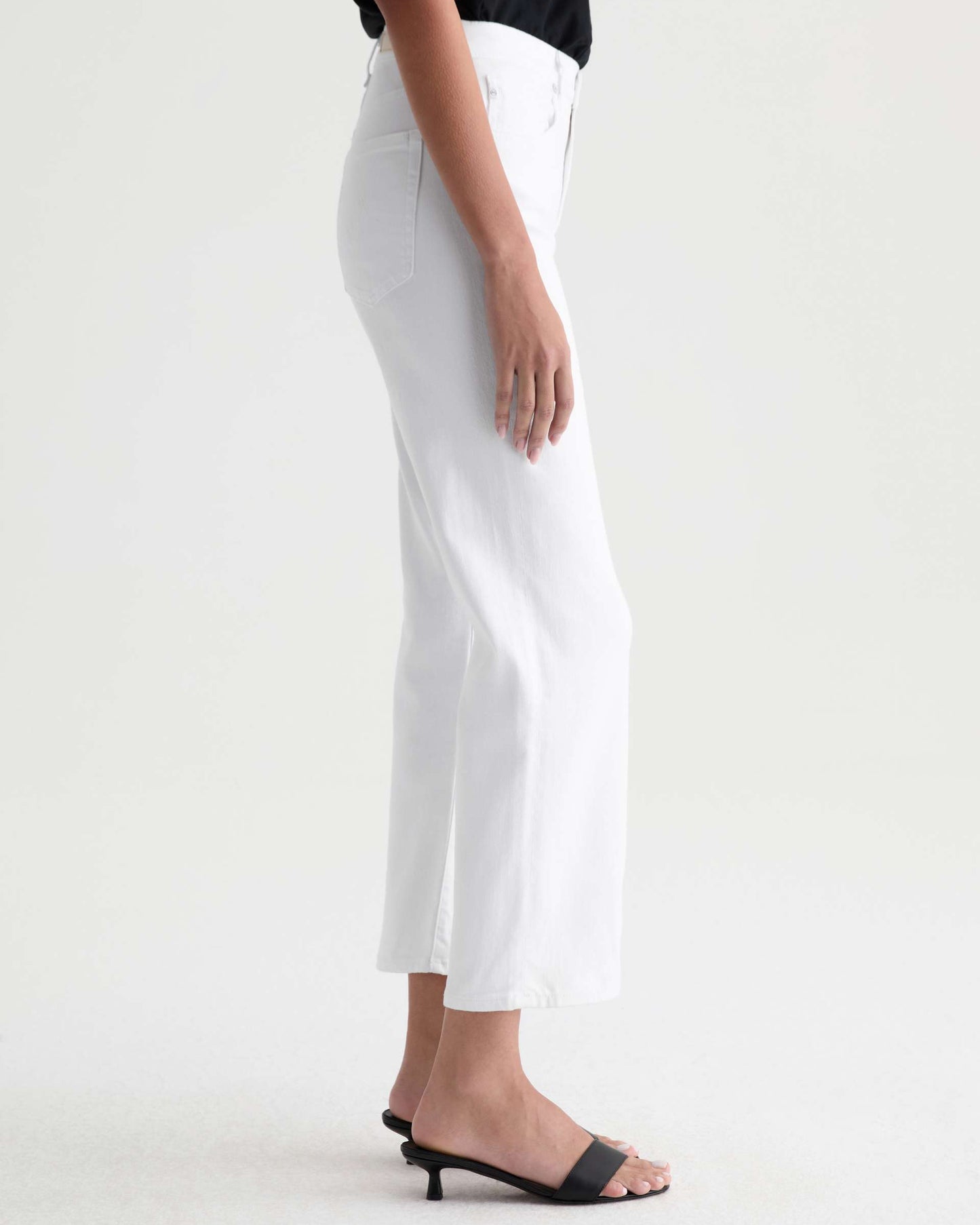 White pants worn by a person on a white background