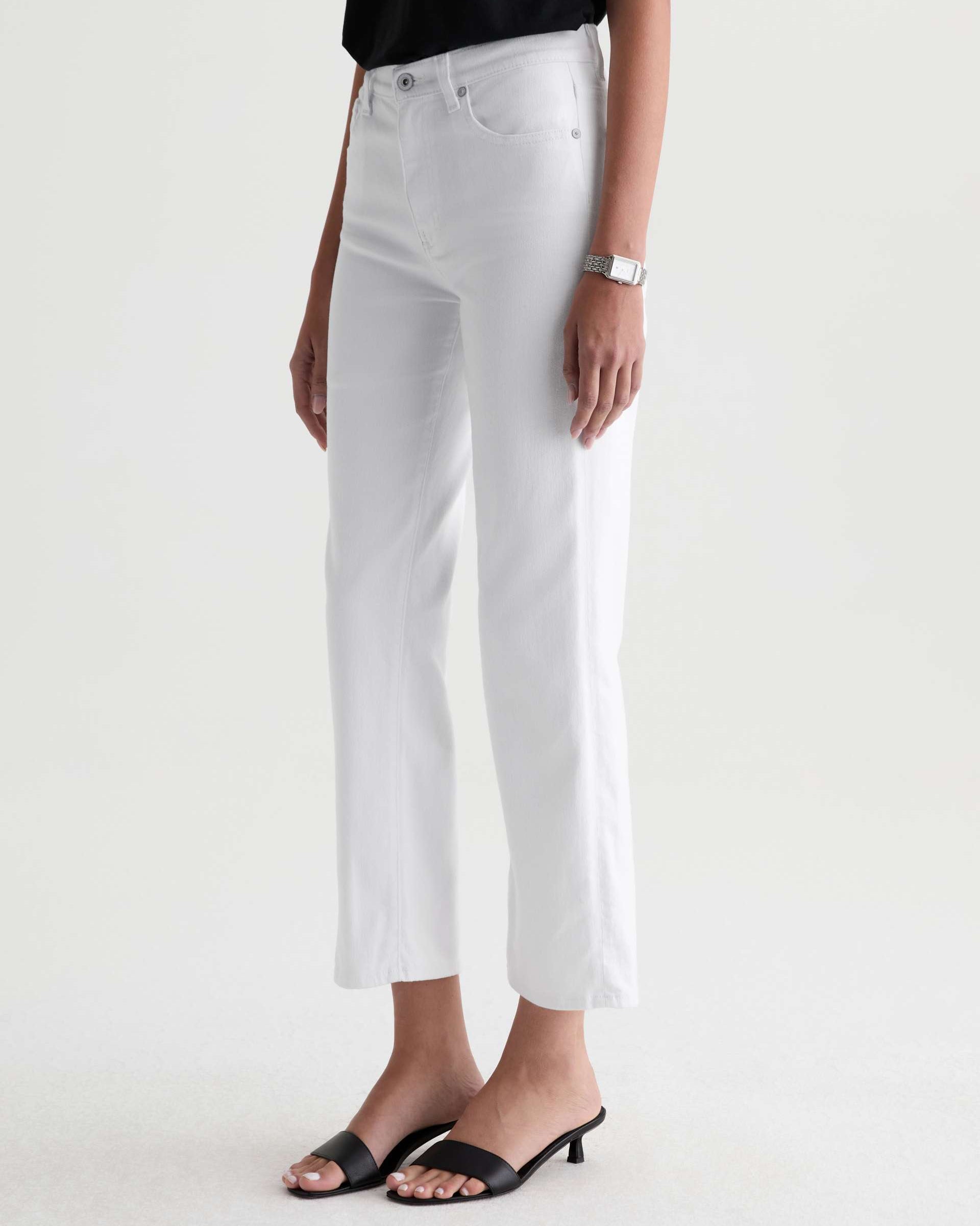 Person wearing white jeans on a plain background