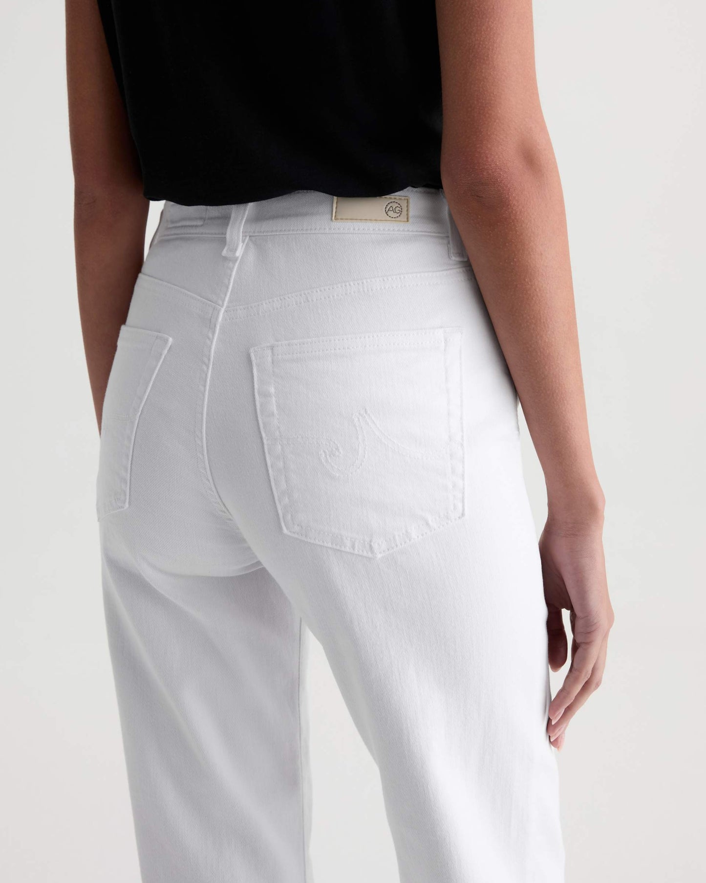 White jeans worn by a person on a white background