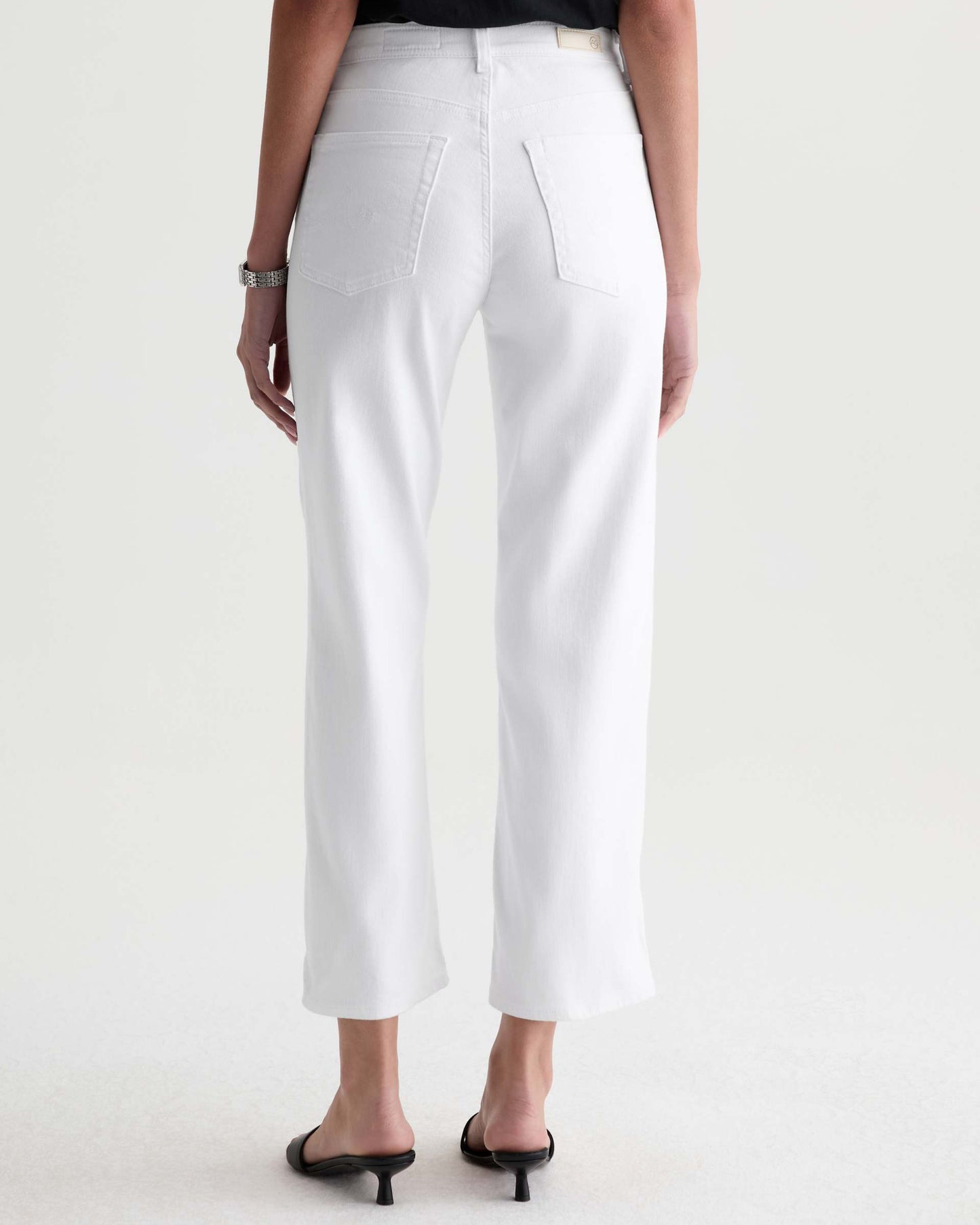 Person wearing white pants on a plain background