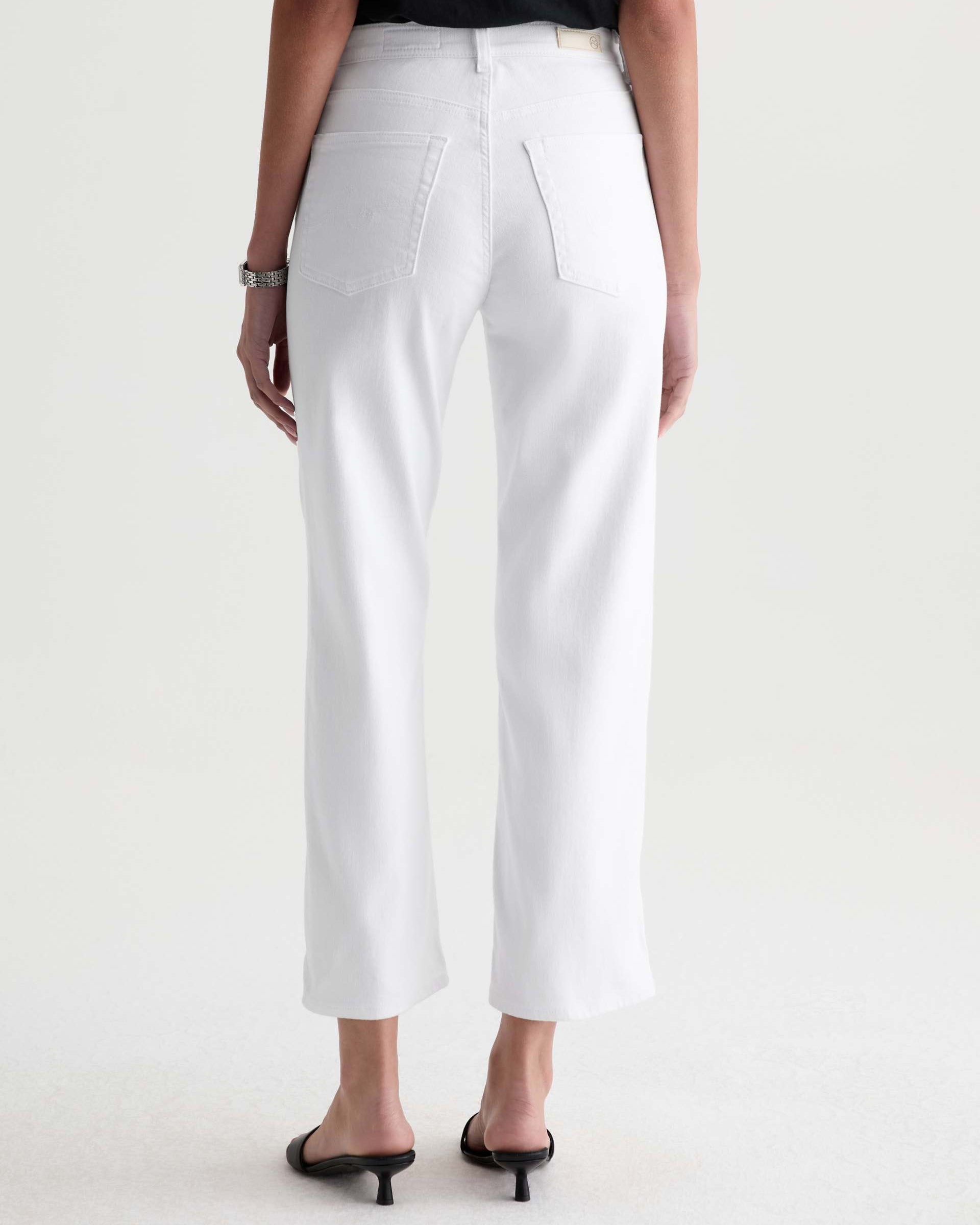 Person wearing white pants on a plain background