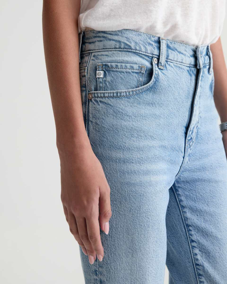 Light blue jeans worn by a person on a plain background