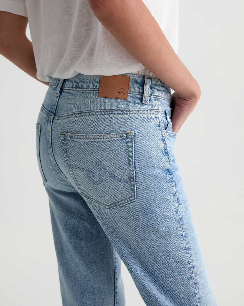 Light blue jeans with a brand logo on the back pocket against a white background