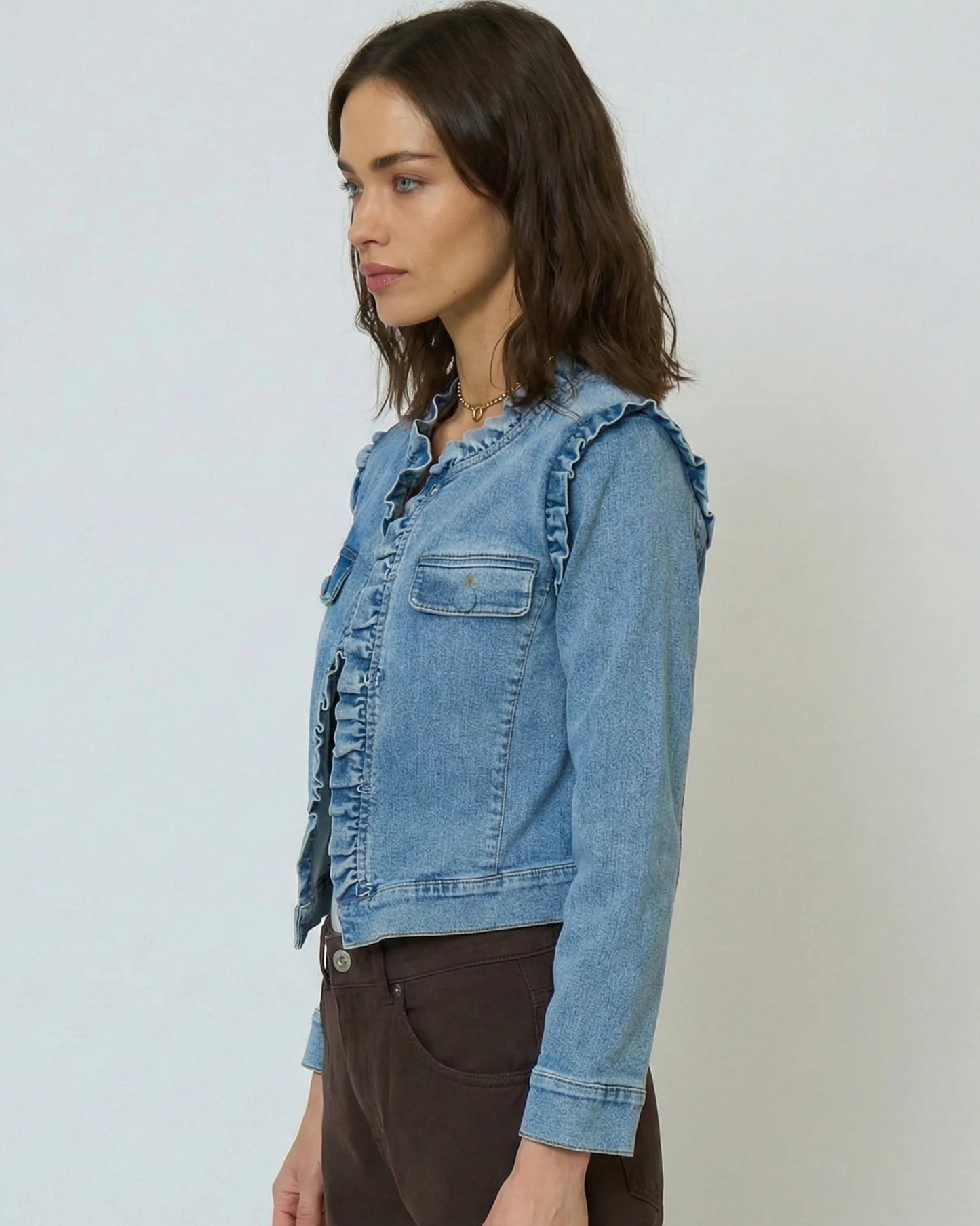 Woman wearing a denim jacket against a plain background