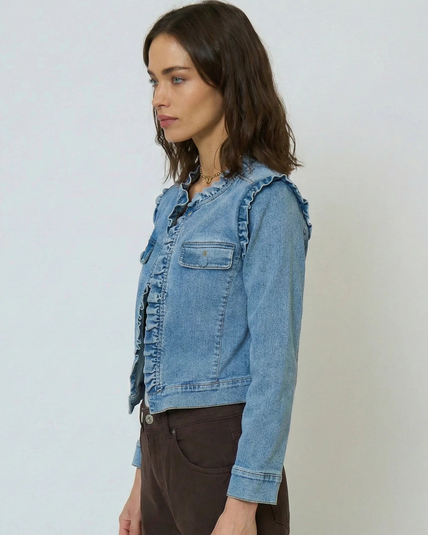 Woman wearing a denim jacket against a plain background
