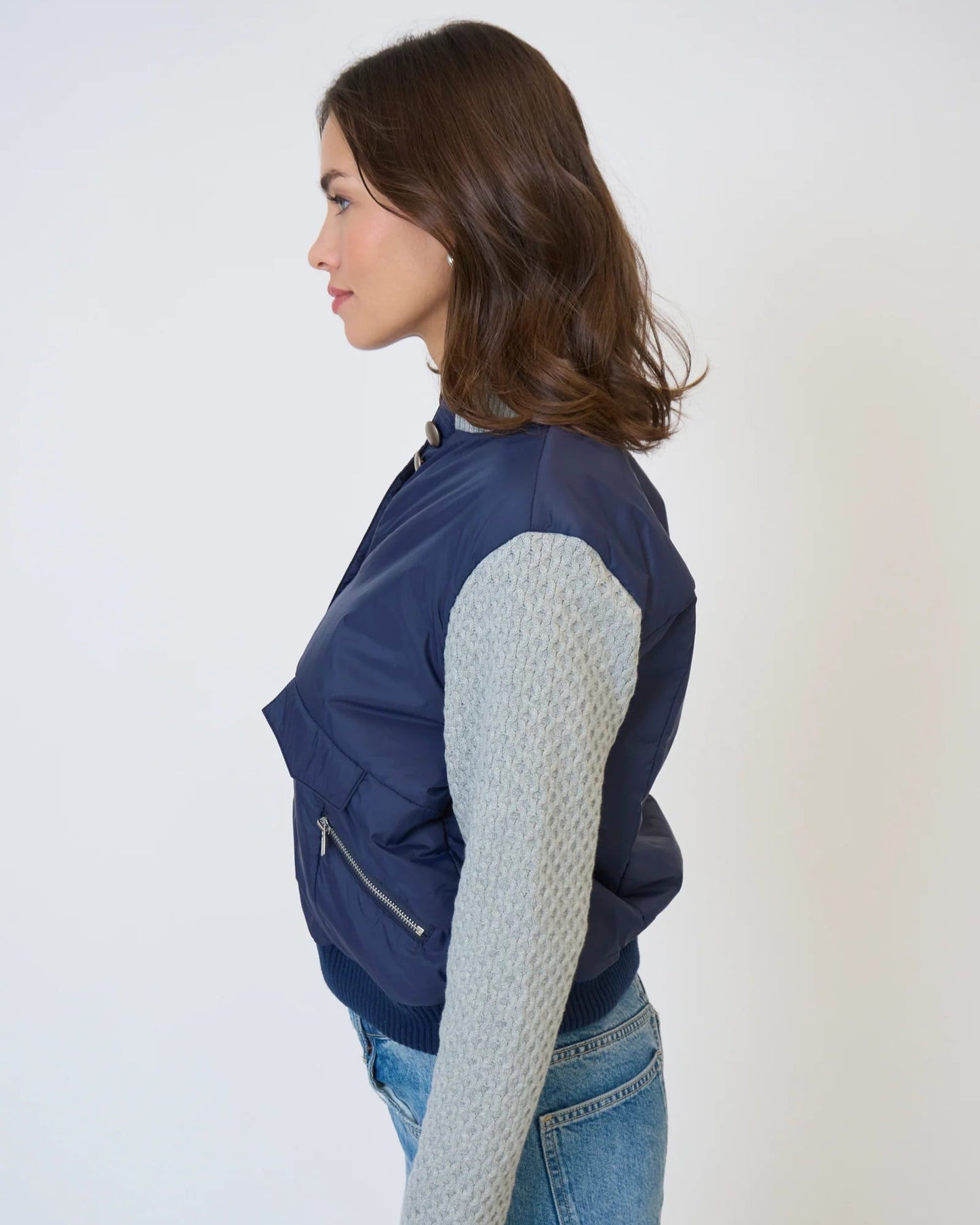 Model is wearing Central Park West Brady Quilted Mixed Media Jacket in Navy on a white background. 