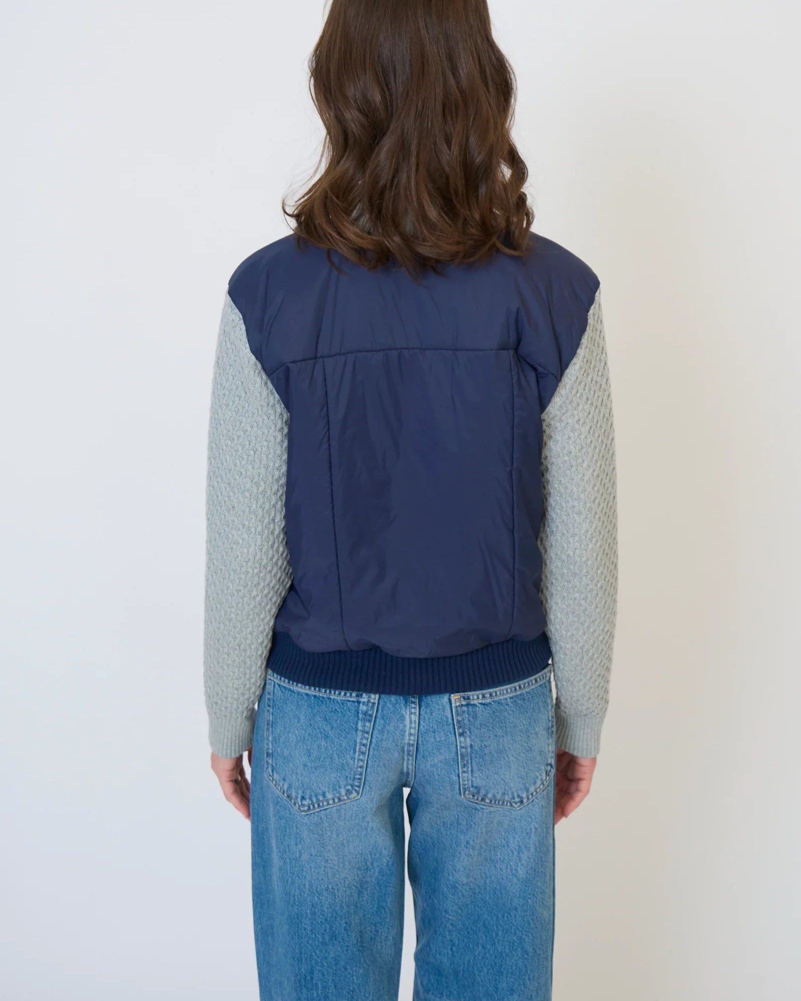 Model is wearing Central Park West Brady Quilted Mixed Media Jacket in Navy on a white background. 