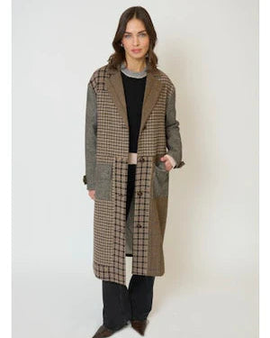 Woman wearing a long plaid coat on a white background