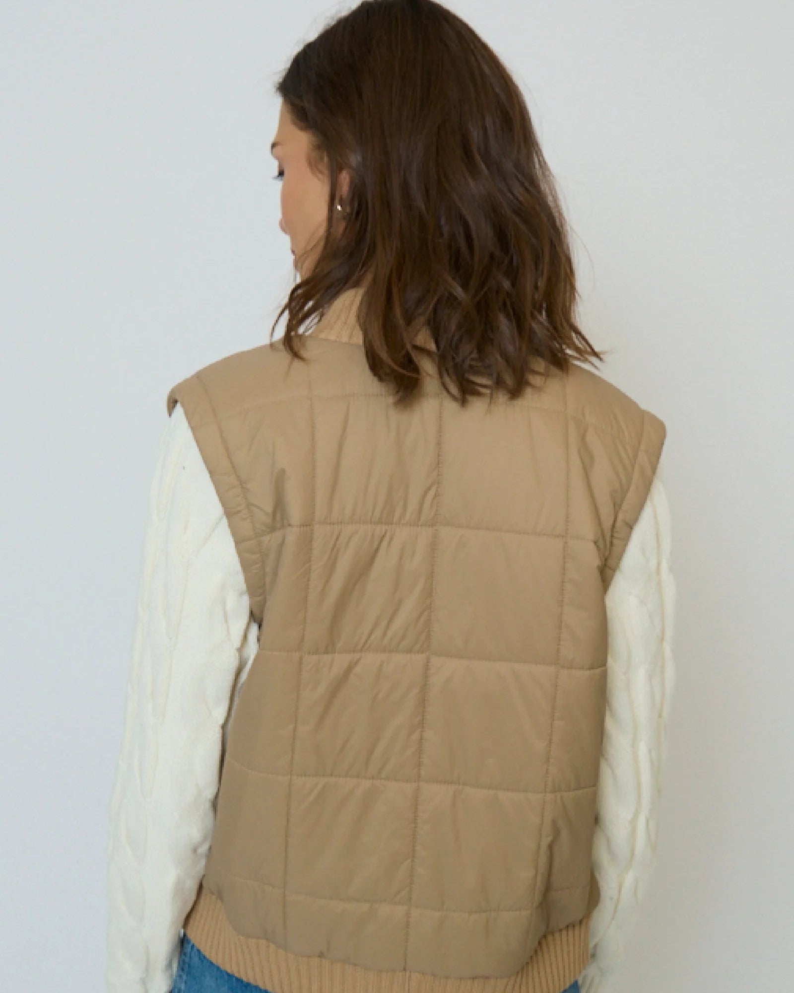 Back view of model wearing the Central Park West Brady Quilted Mixed Media Jacket in Oat on a white background