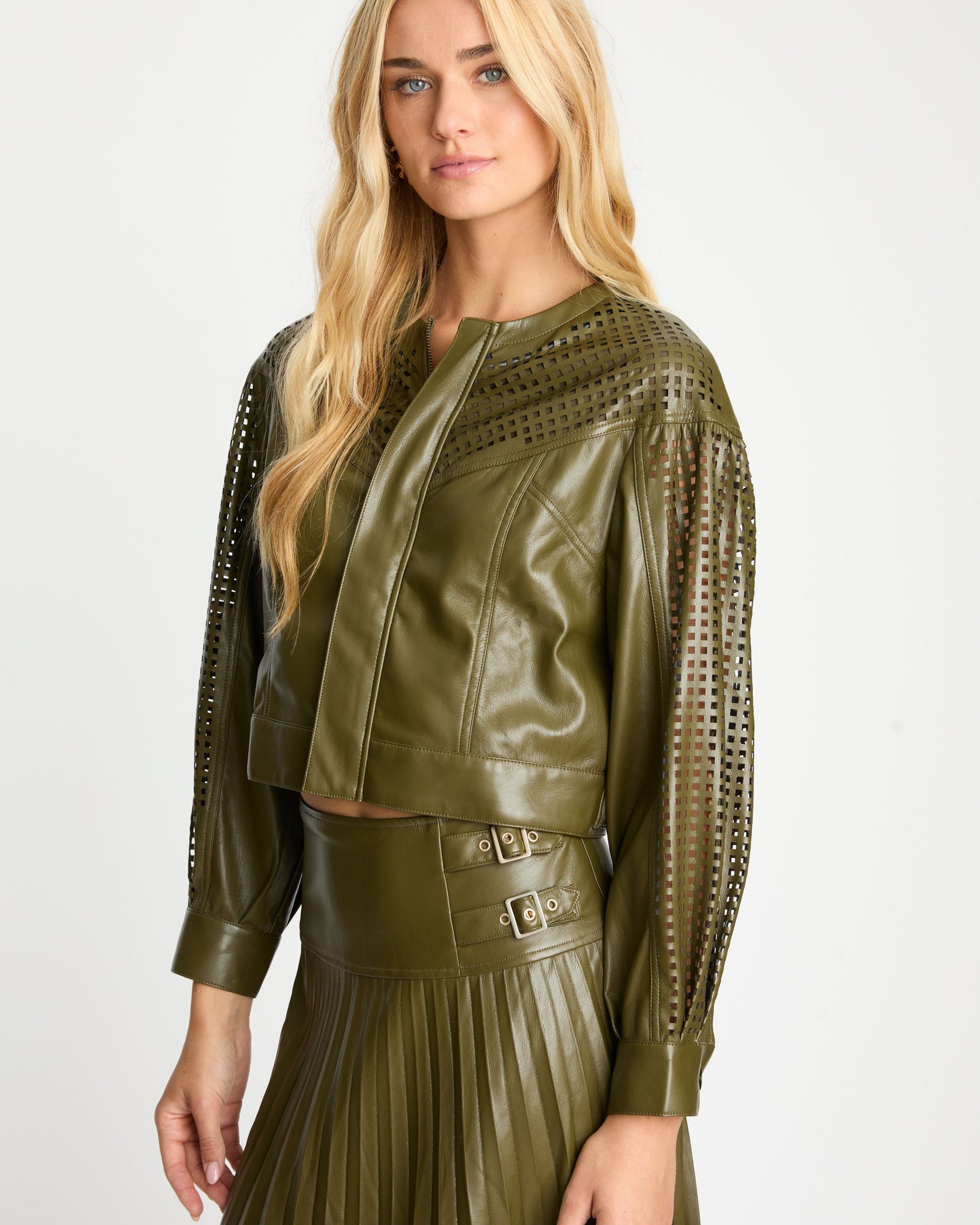Woman wearing a green leather outfit with a white background