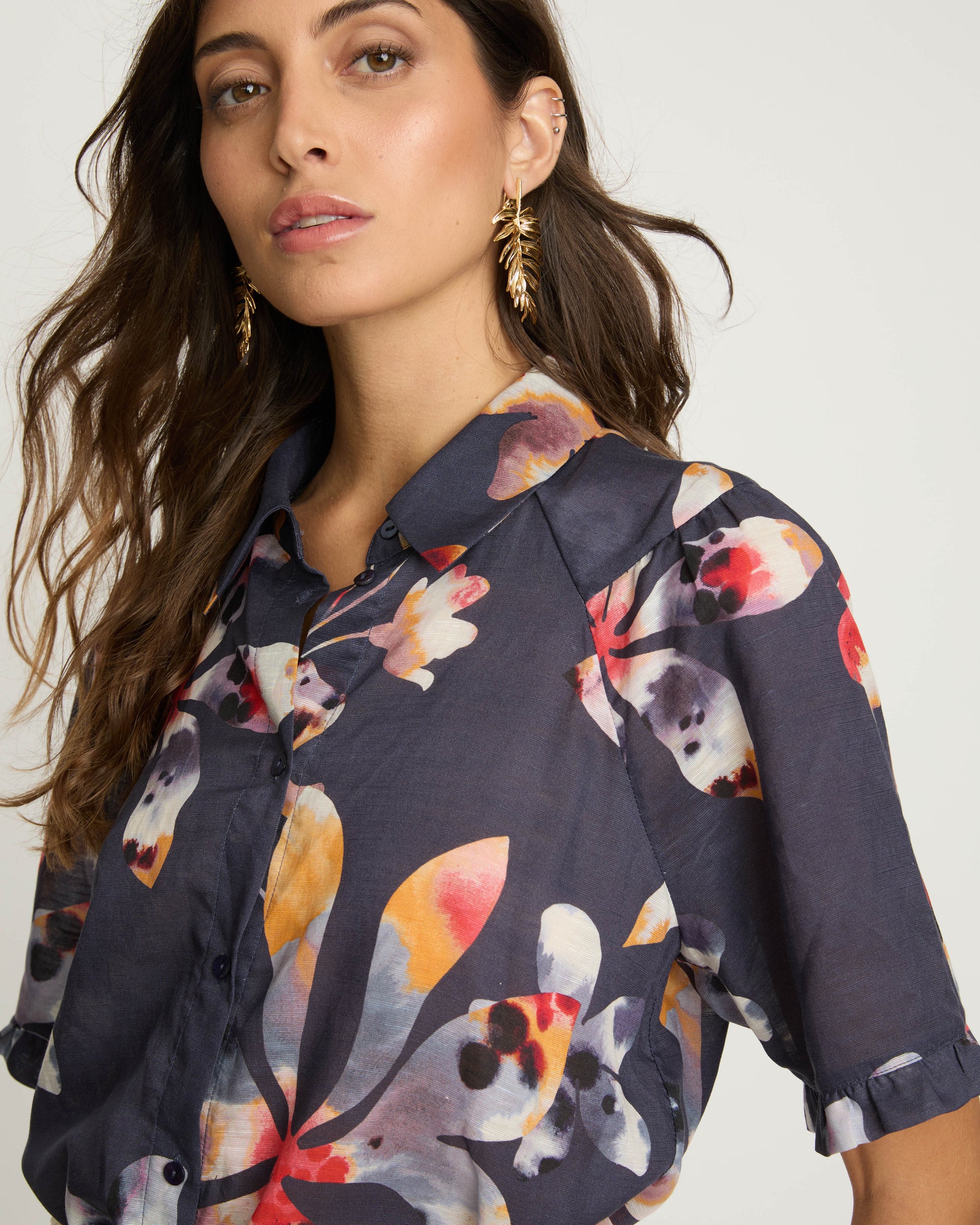 Woman wearing a navy floral blouse against a plain background