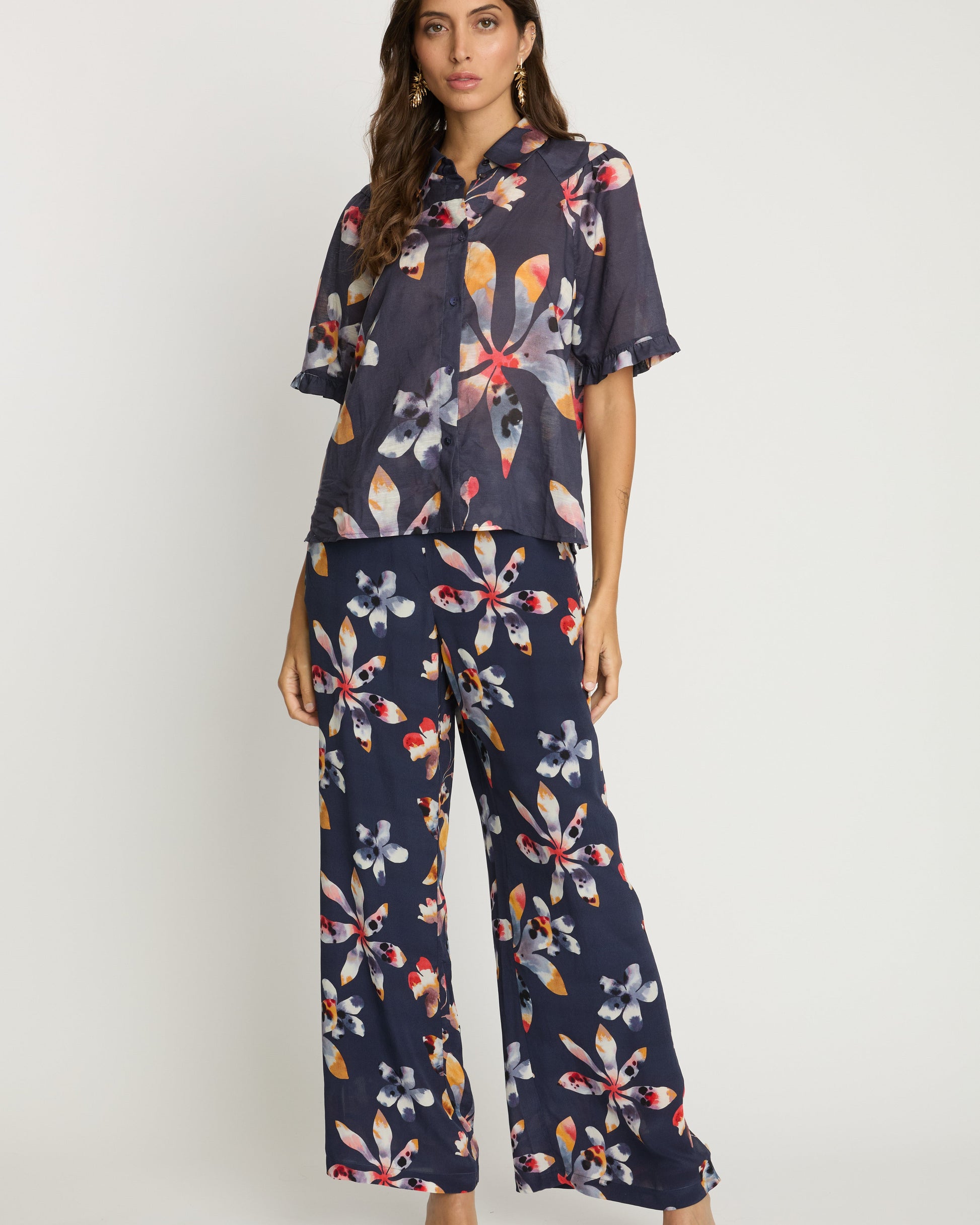 Woman wearing a navy floral outfit on a white background