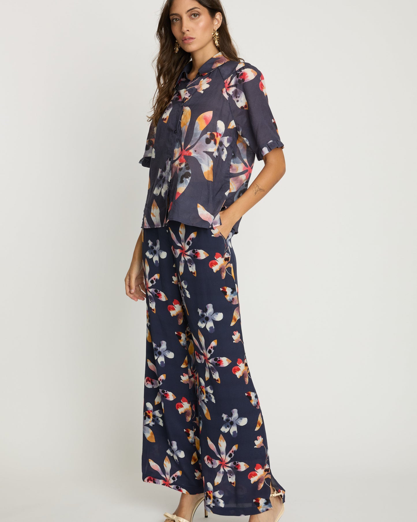Woman wearing a navy floral outfit on a white background