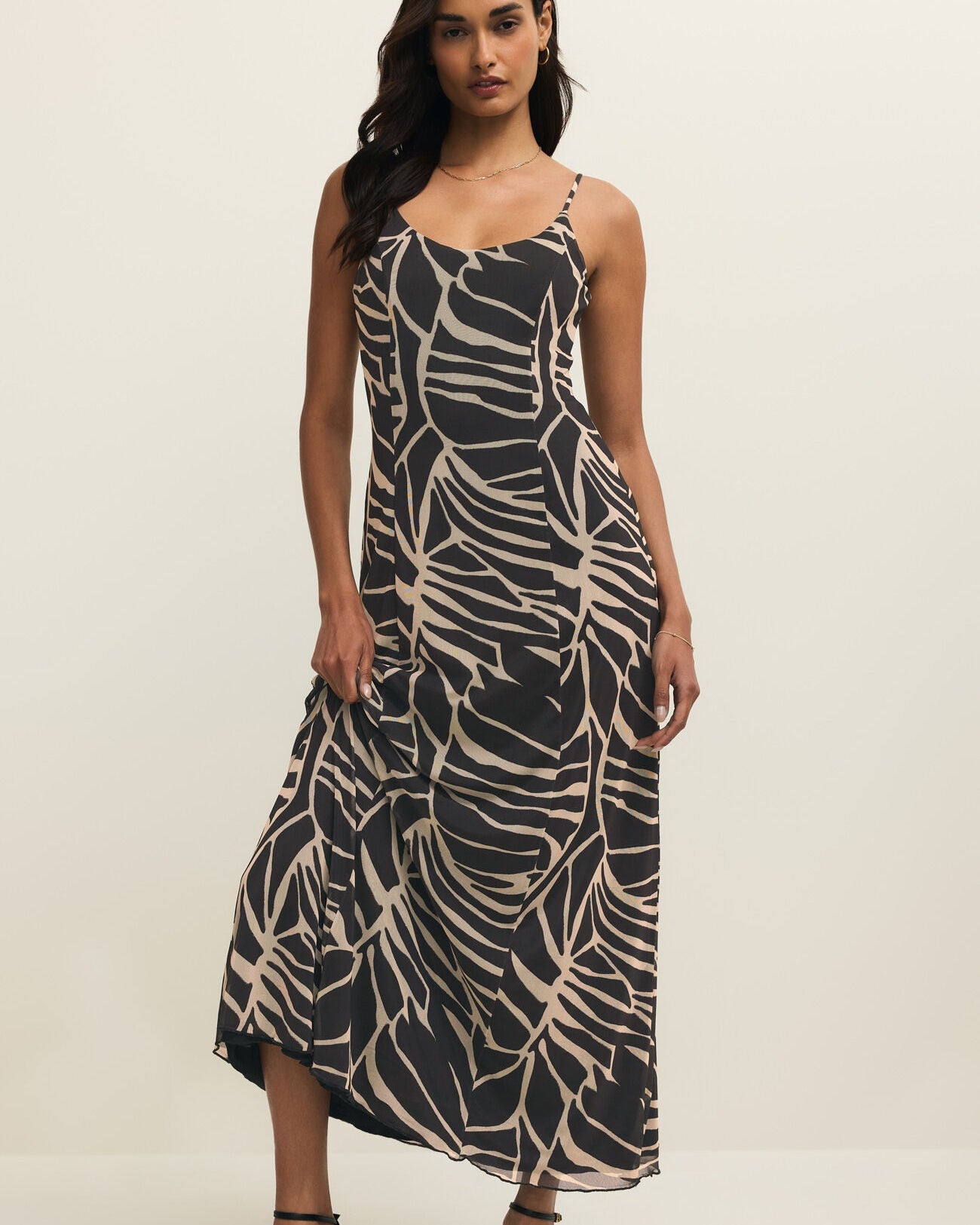 Woman wearing a black and beige patterned dress on a white background