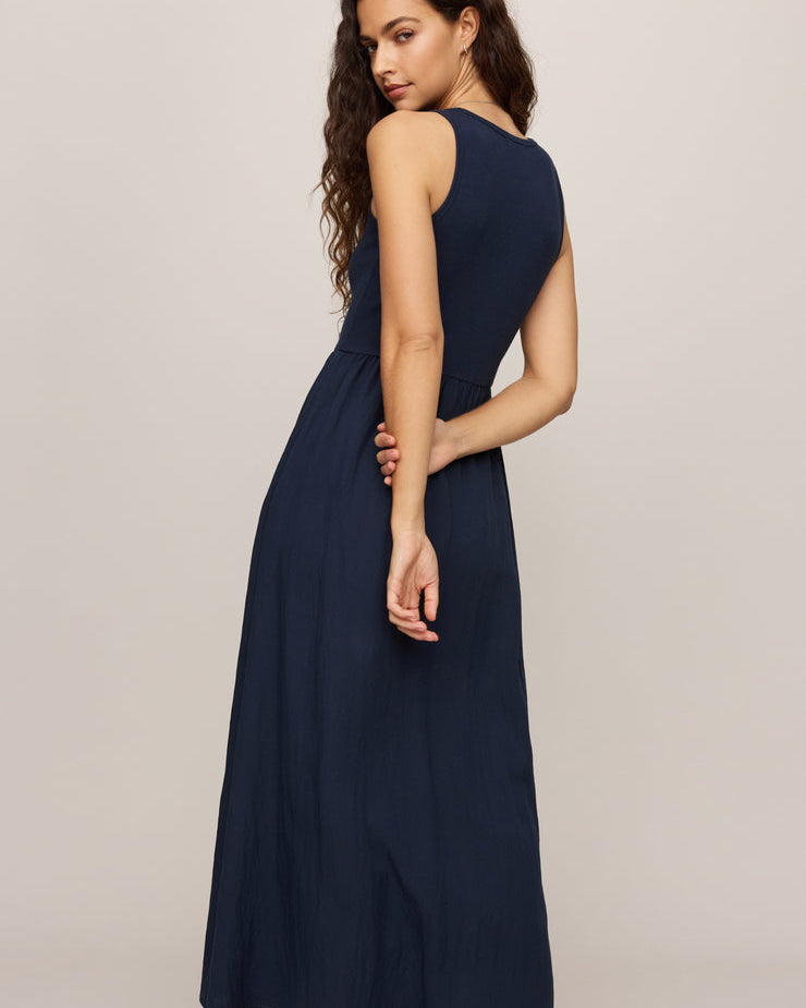 Woman wearing a navy blue dress against a plain background