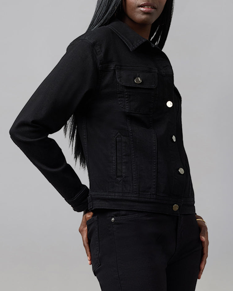 Person wearing a black denim jacket on a gray background
