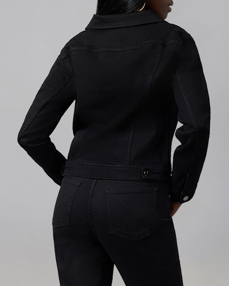 Person wearing a black jacket and pants on a gray background