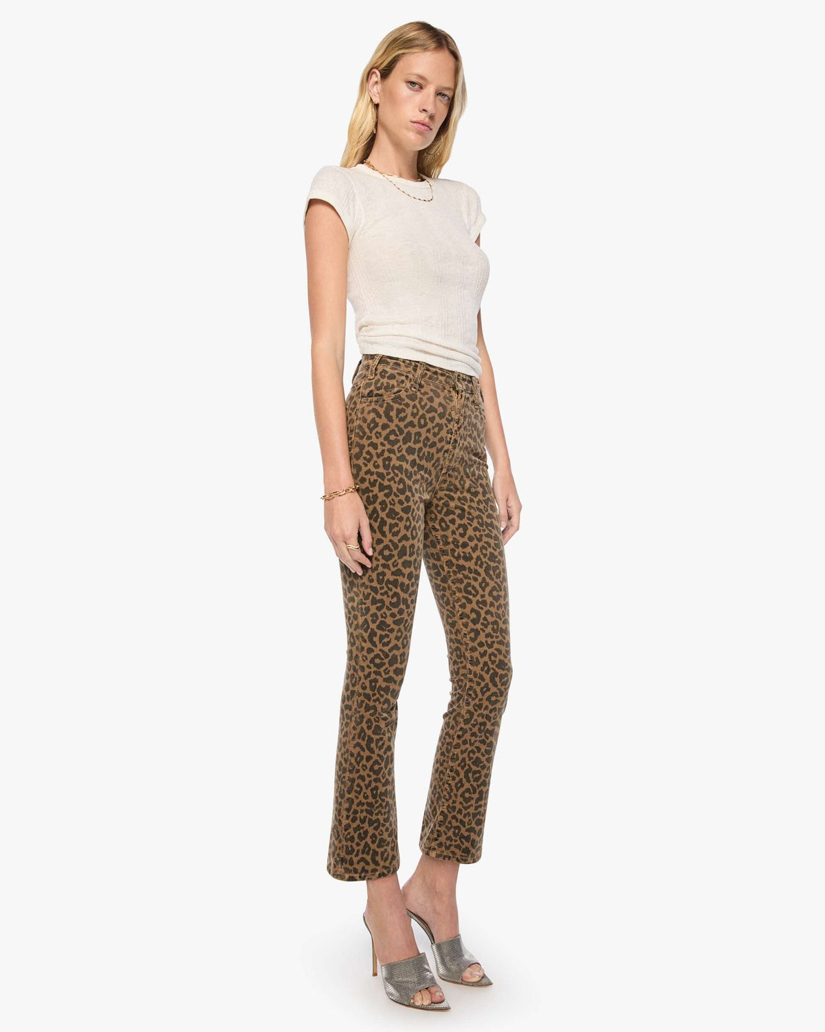 Woman wearing a white top and leopard print pants on a white background