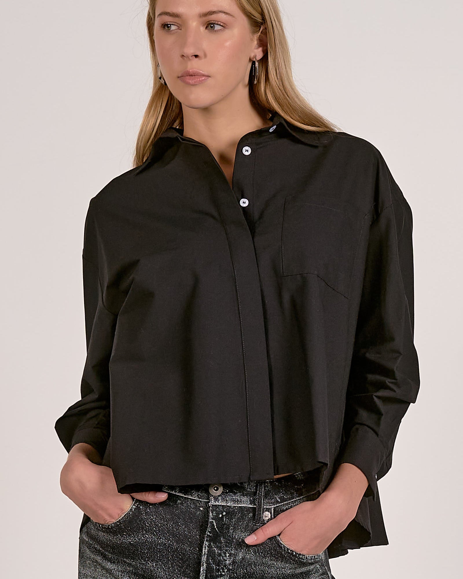 Woman wearing a black shirt with a plain background