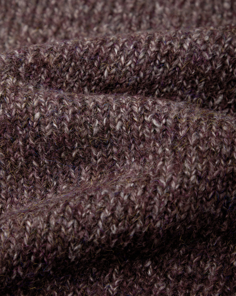 Close-up of a heathered knit fabric in a dark brownish-purple tone, showing the textured stitch pattern and soft folds.