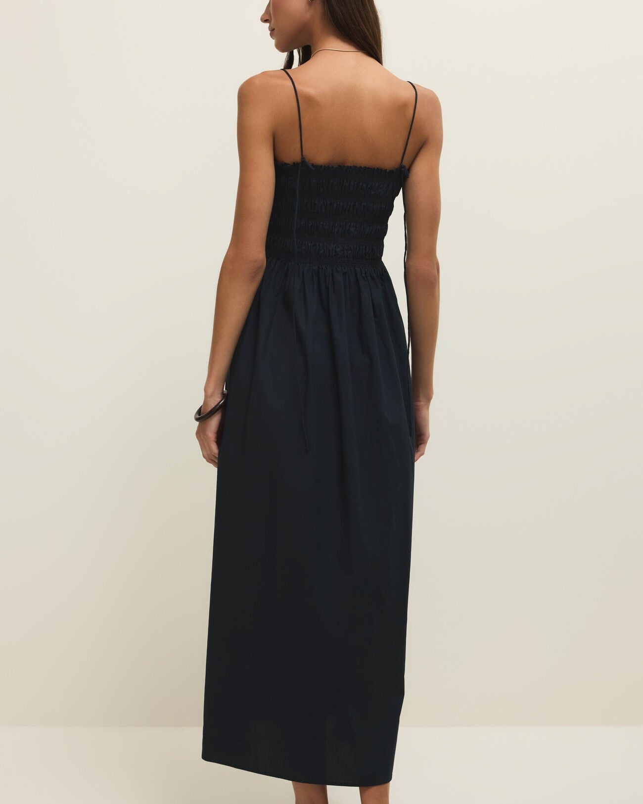 Woman wearing a black dress on a plain background