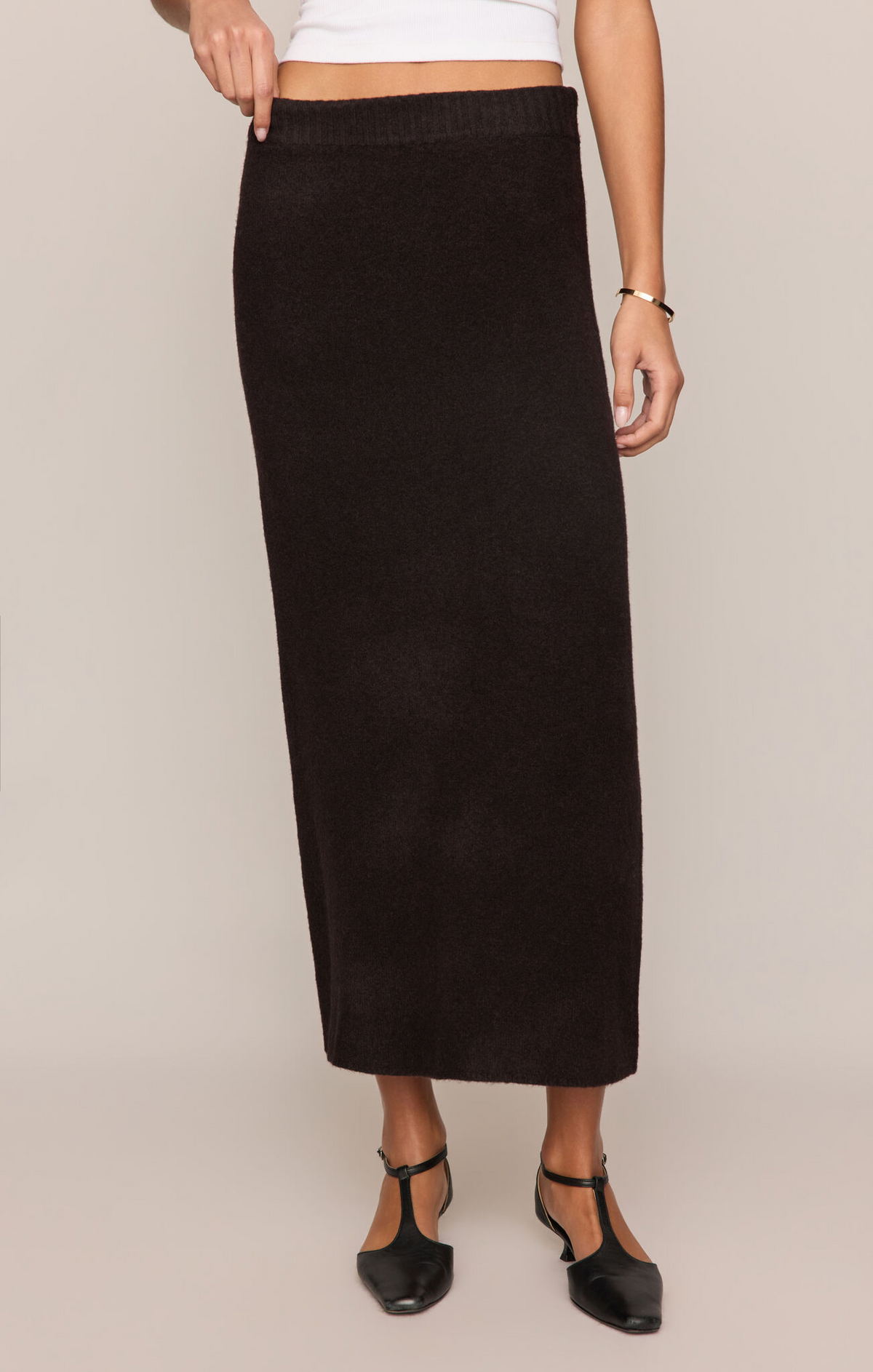 Person wearing a black skirt on a plain background