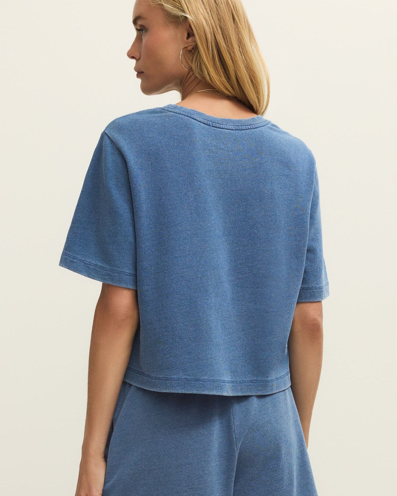 Woman wearing a blue outfit on a beige background