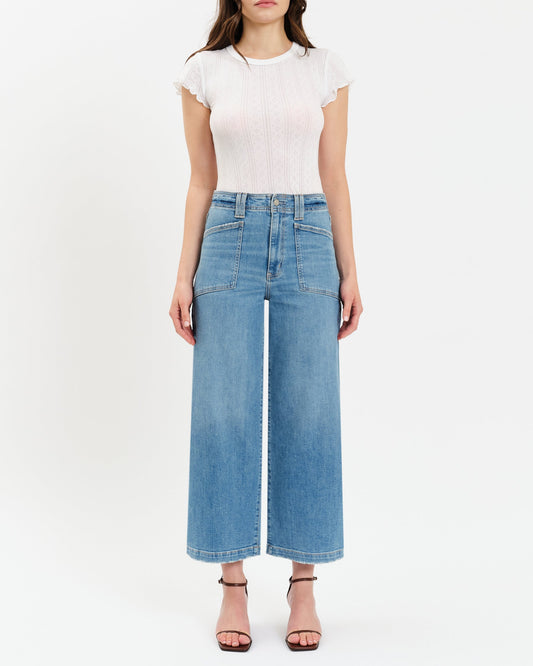 Person wearing a white top and blue jeans on a white background