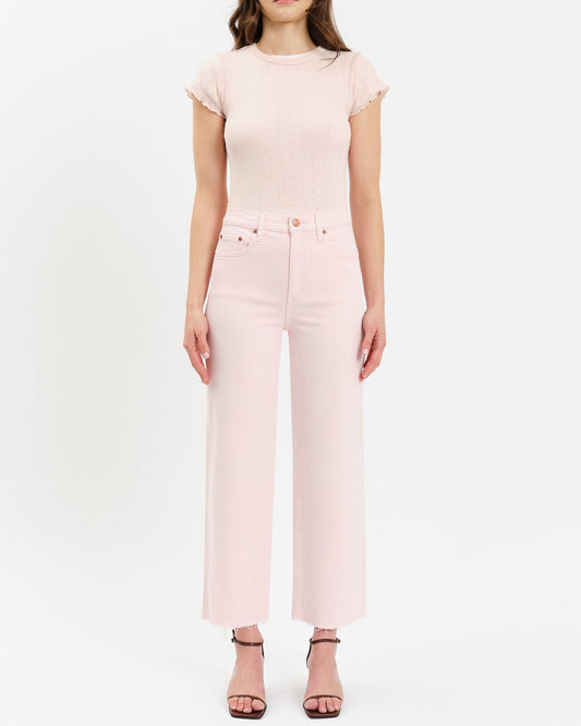 Woman wearing a pink top and pants on a white background