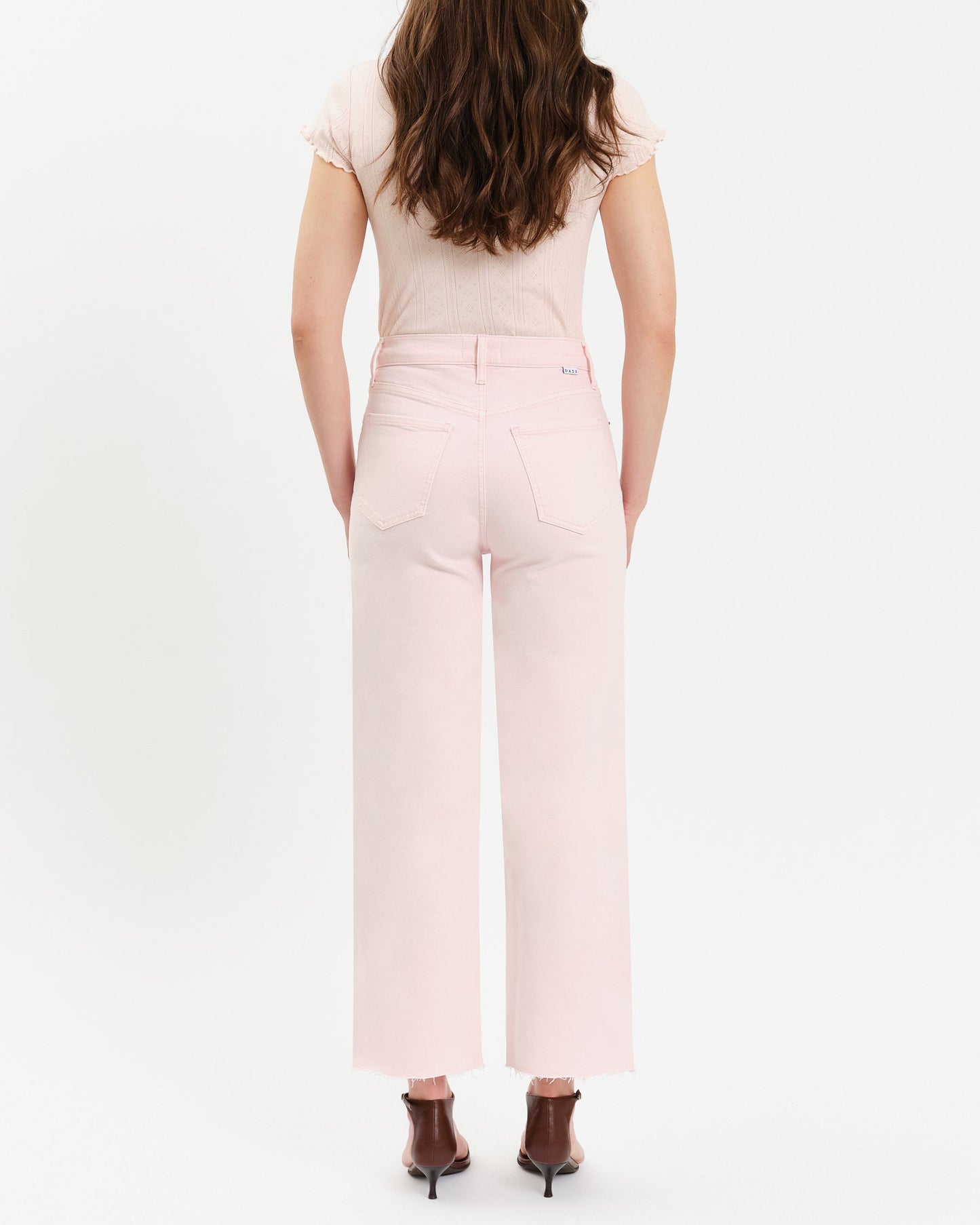 Person wearing a light pink outfit with a white background