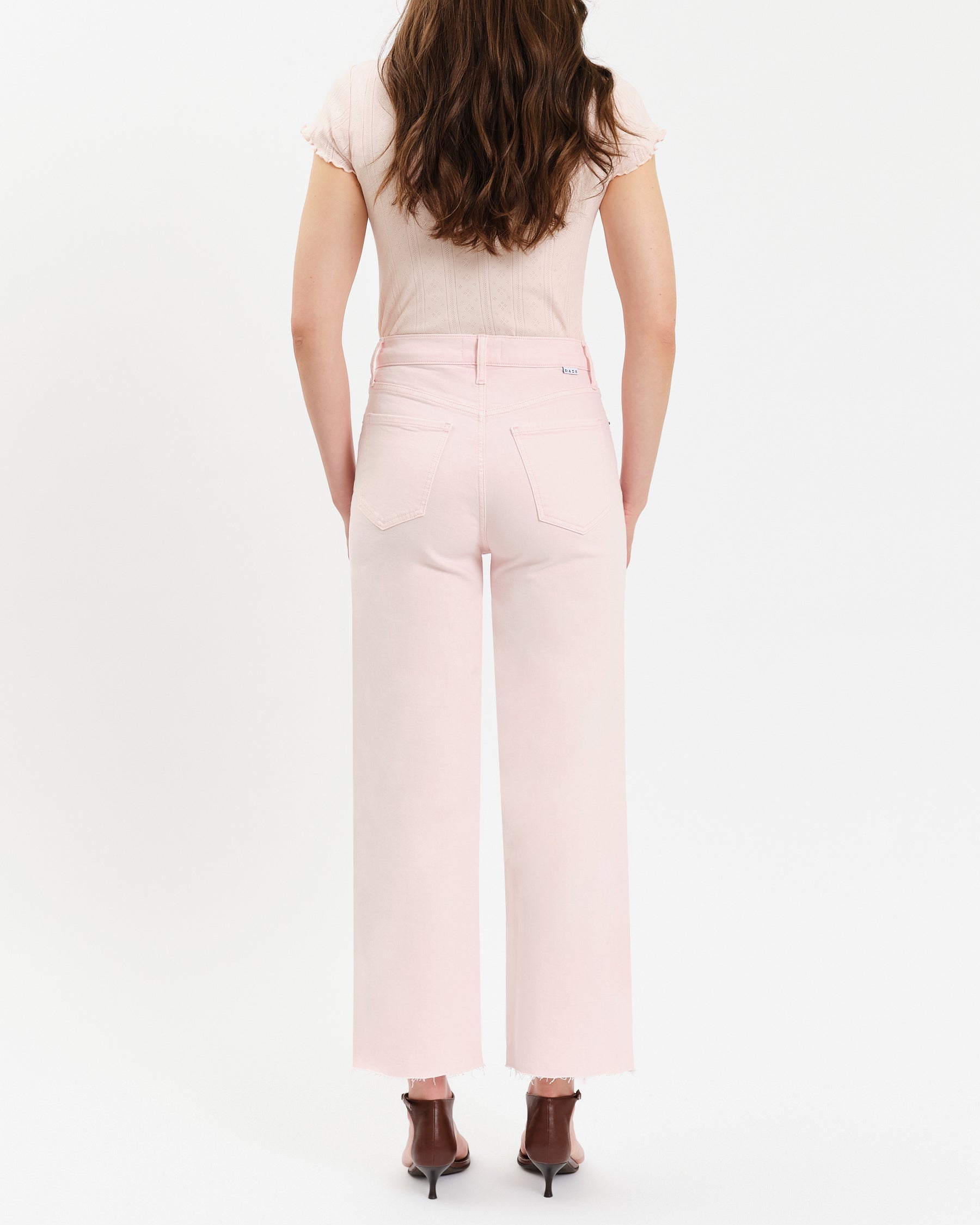 Person wearing a light pink outfit with a white background