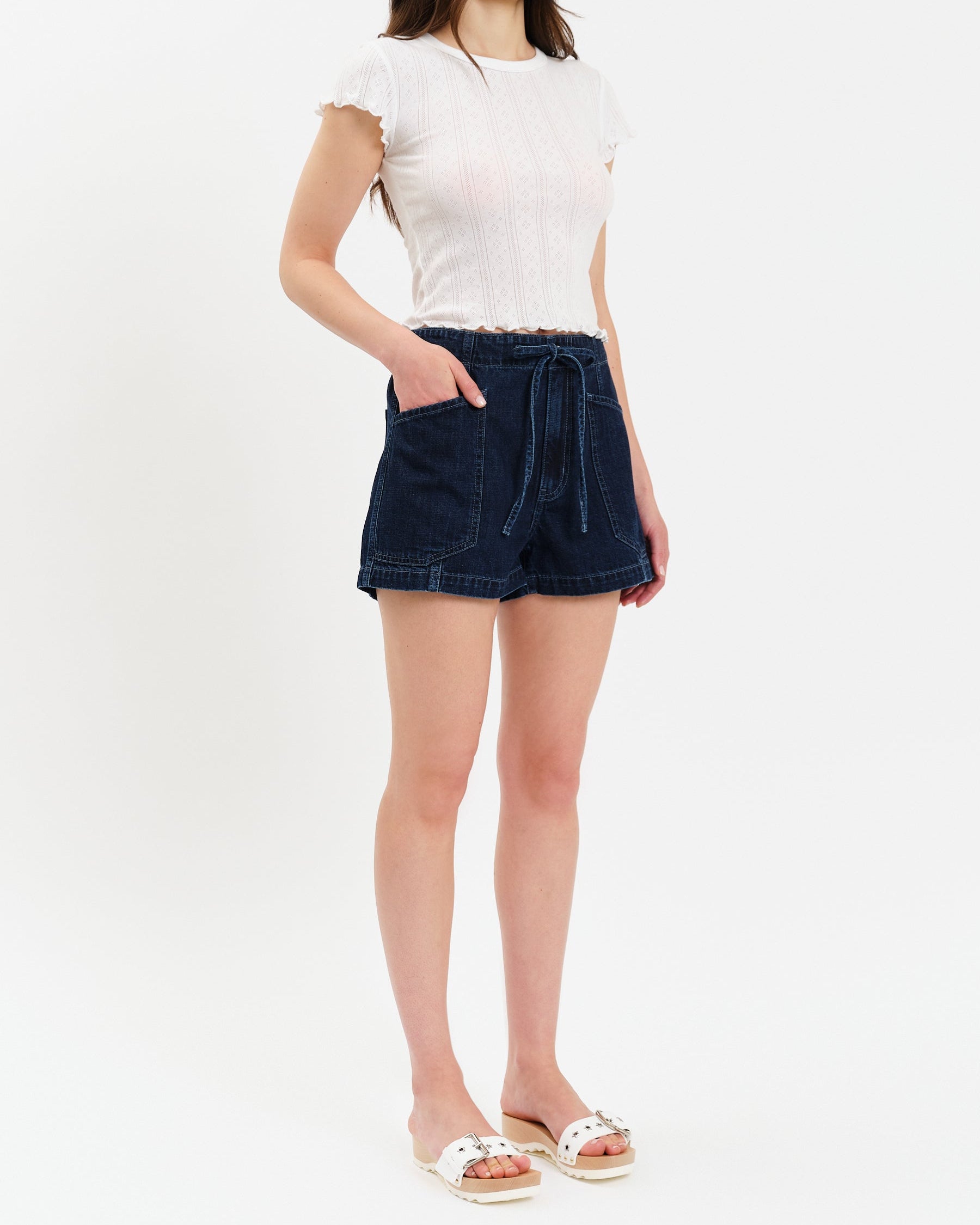Woman wearing a white t-shirt and dark denim skirt on a white background