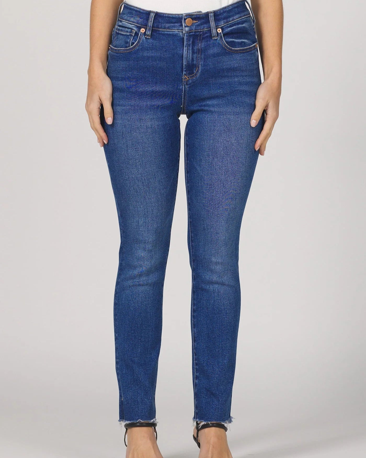 Person wearing blue jeans on a plain background