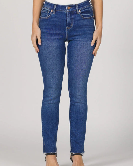 Person wearing blue jeans on a plain background