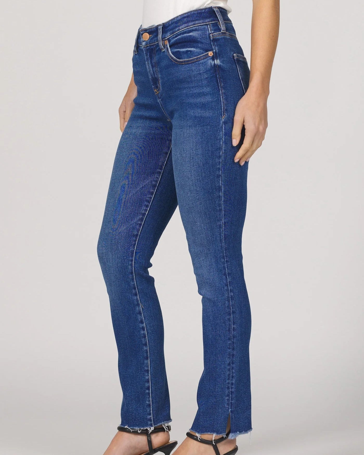 Blue jeans worn by a person on a plain background