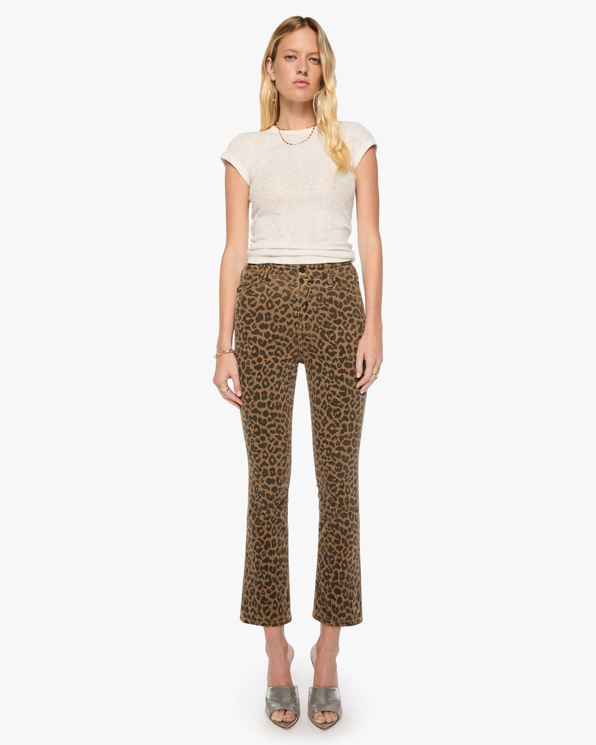 Woman wearing a white top and leopard print pants on a white background