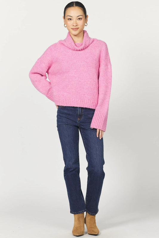 Person wearing a pink sweater and blue jeans on a white background
