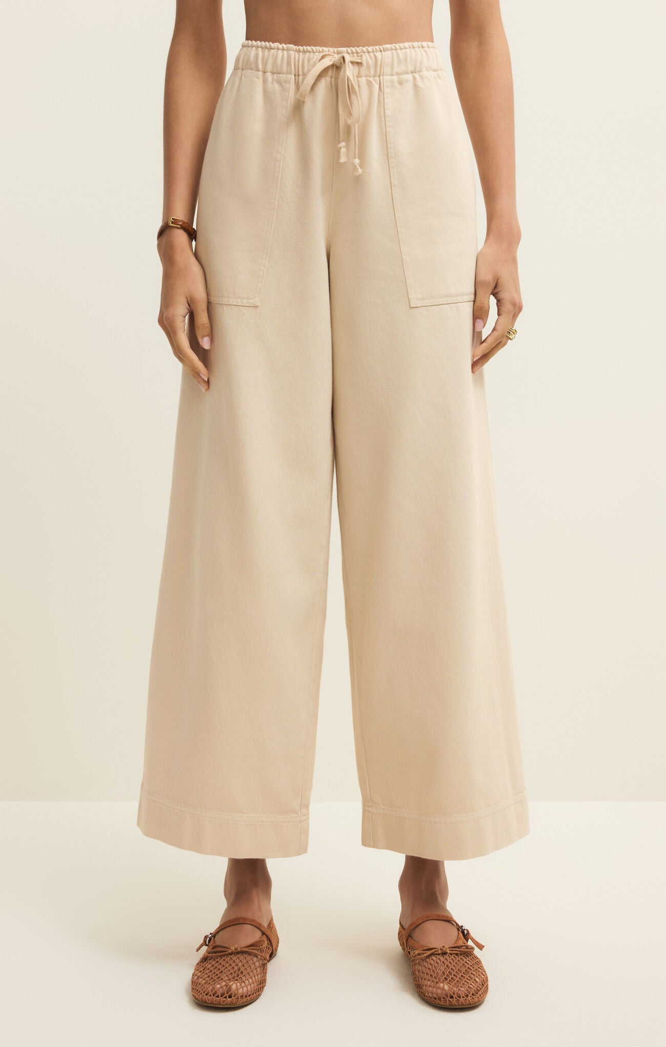 Beige wide-leg pants worn by a person on a plain background