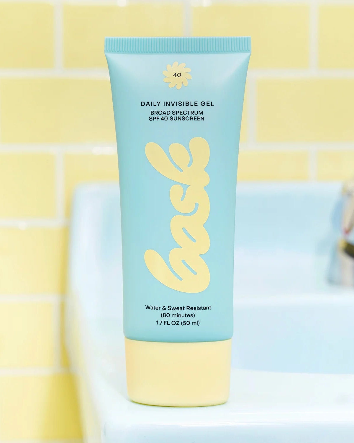 Tube of 'Bask' daily invisible gel sunscreen on a yellow tiled background