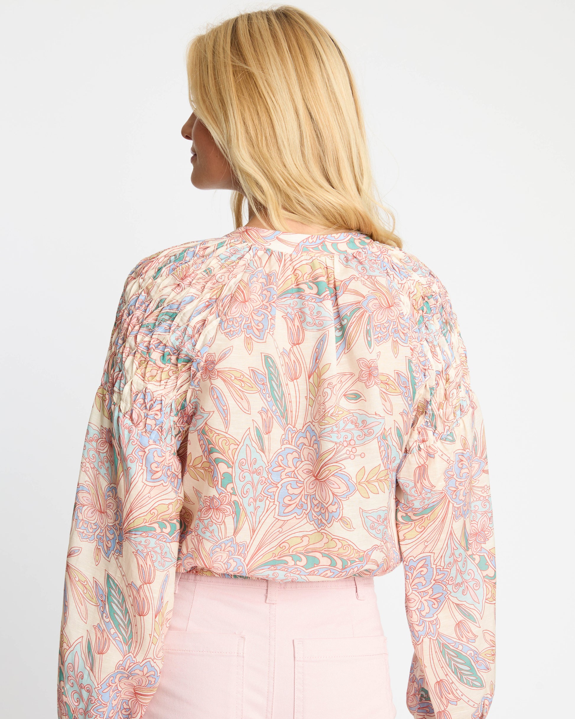 Woman wearing a floral blouse with long sleeves on a white background