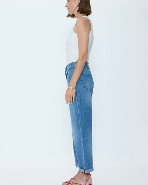 Woman wearing a white top and blue jeans on a white background