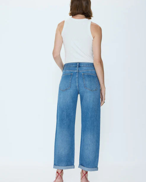 Woman wearing blue jeans and a white top on a white background