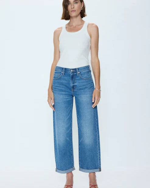 Woman wearing a white tank top and blue jeans on a white background