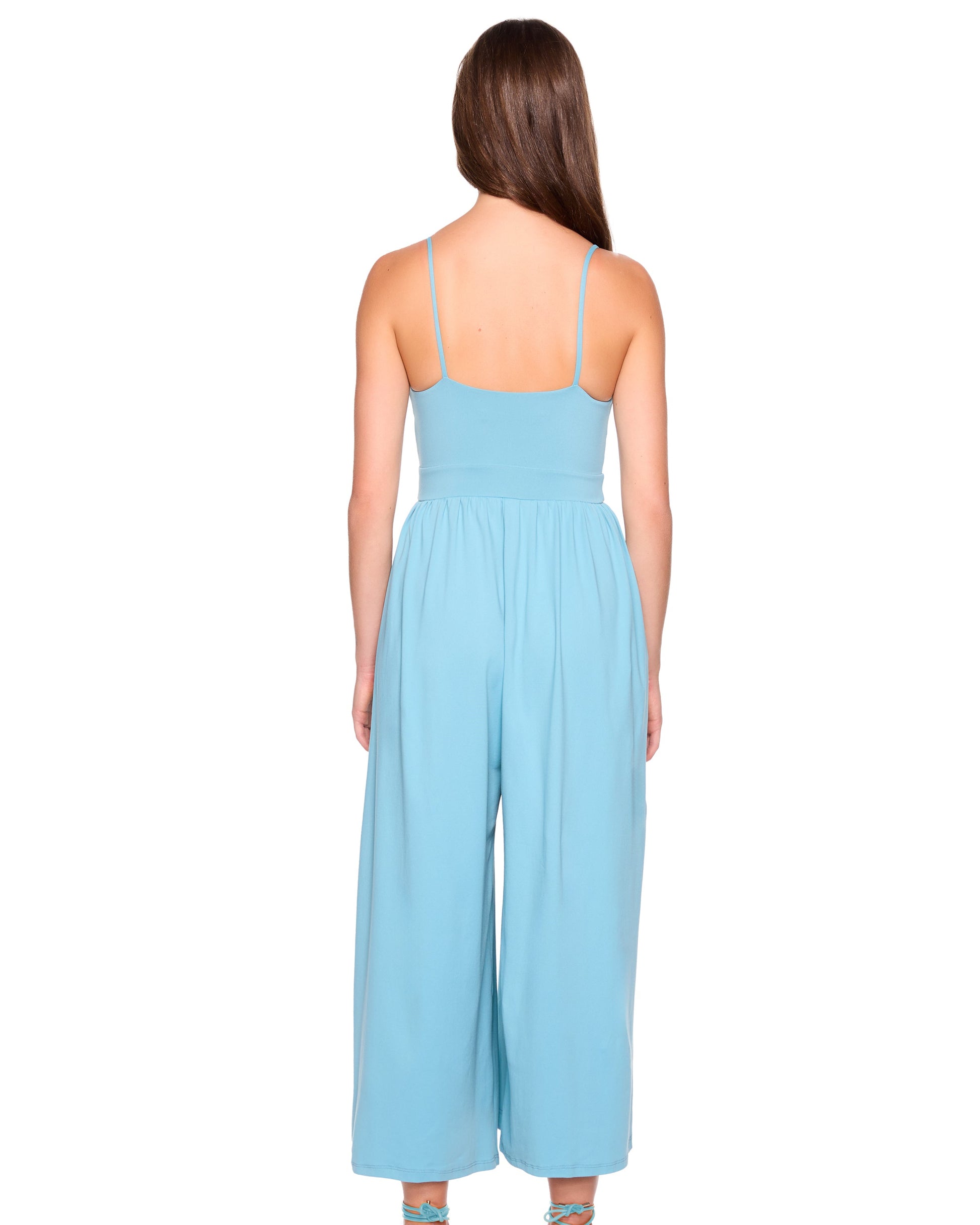 Woman wearing a light blue jumpsuit on a white background