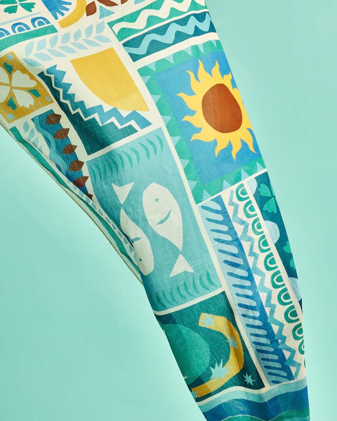 Colorful fabric with beach-themed patterns on a light blue background