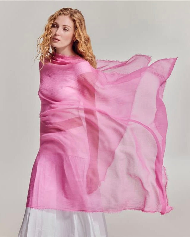 Woman wearing a pink scarf on a plain background