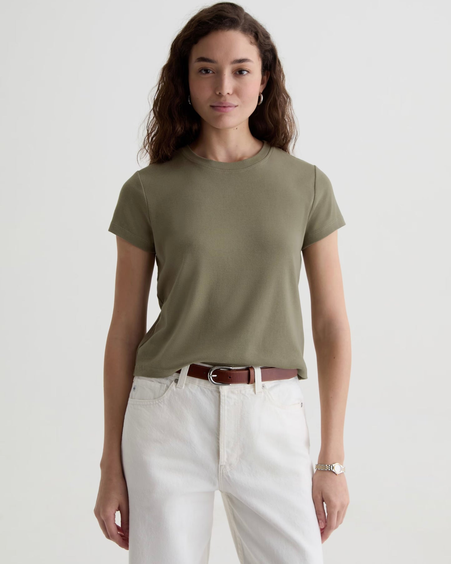 Person wearing a green tee shirt with white jeans against a white background