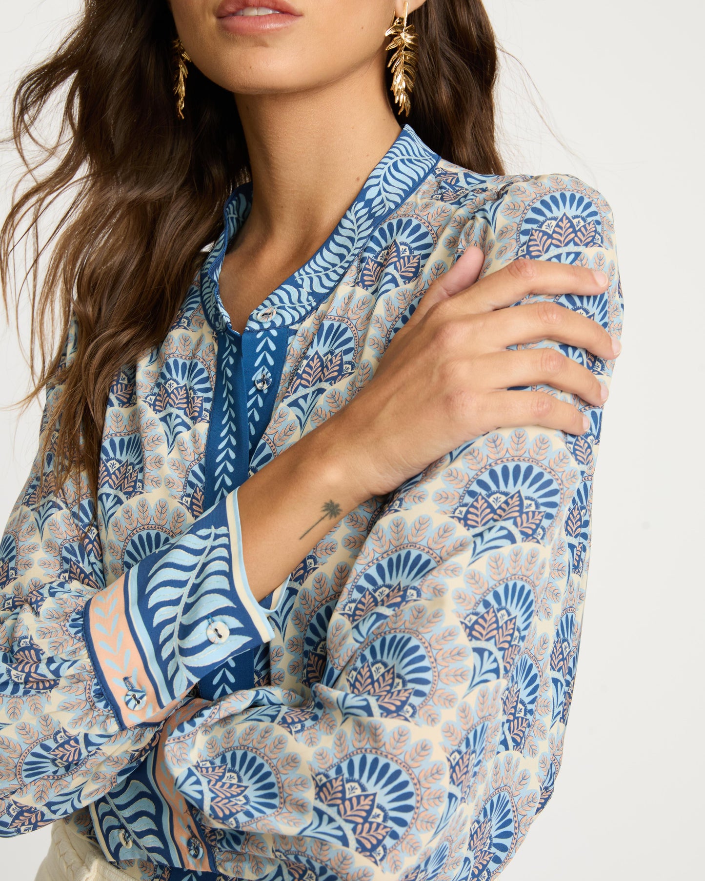 Woman wearing a patterned blouse with a neutral background
